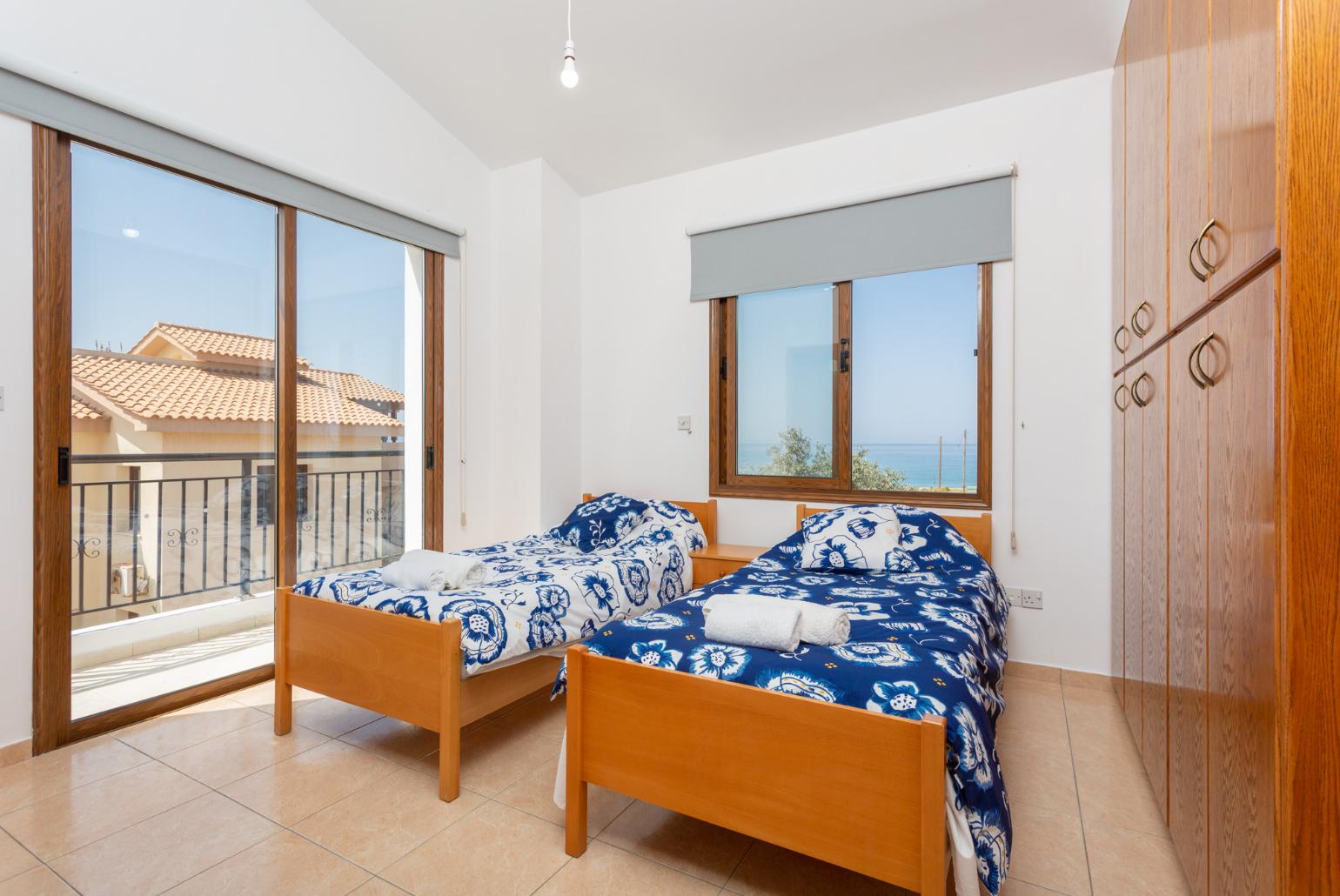 Twin bedroom with en suite bathroom, A/C, and balcony access with sea views