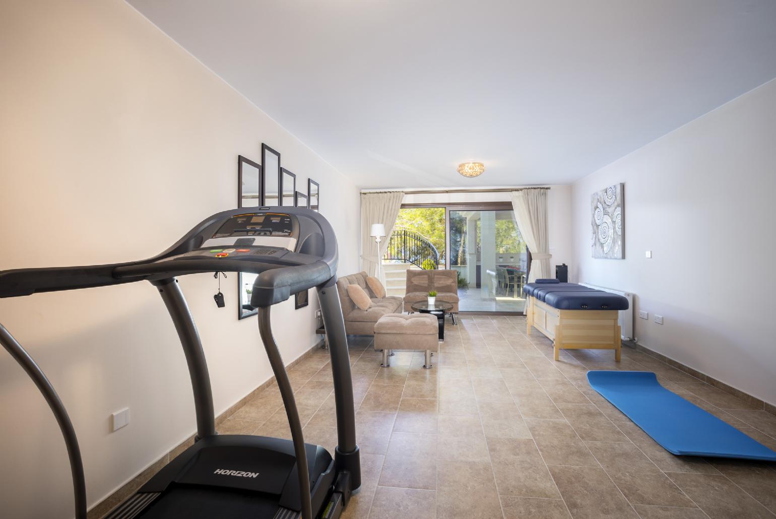Living area with gym equipment and massage table