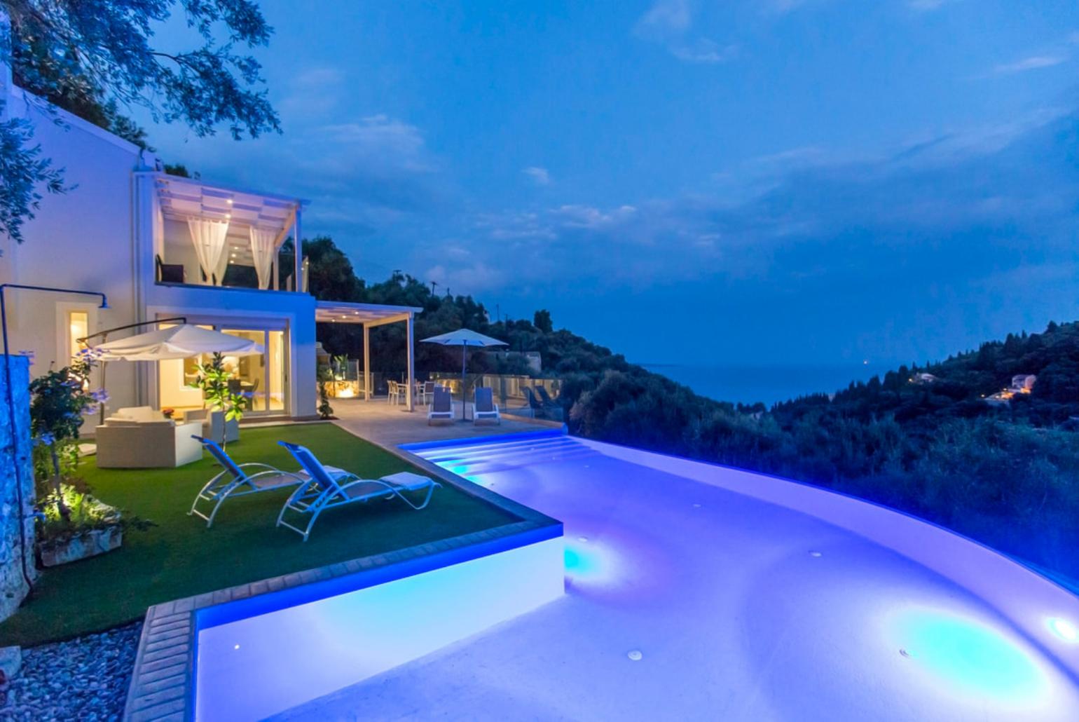 Infinity pool with sea view at night