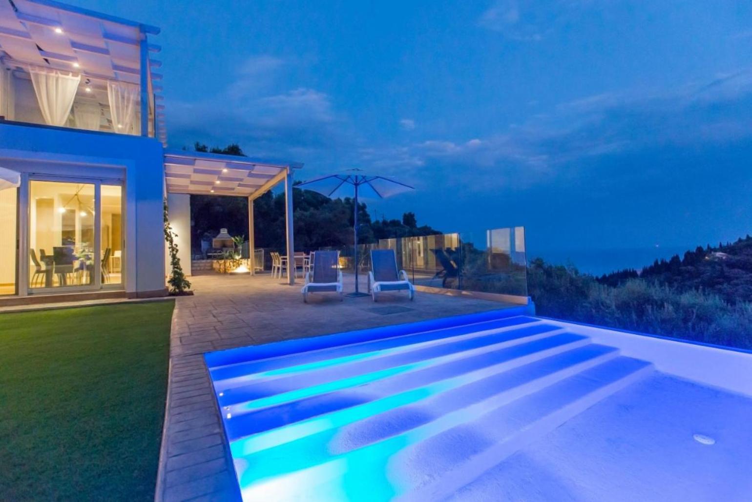 Infinity pool with sea view at night