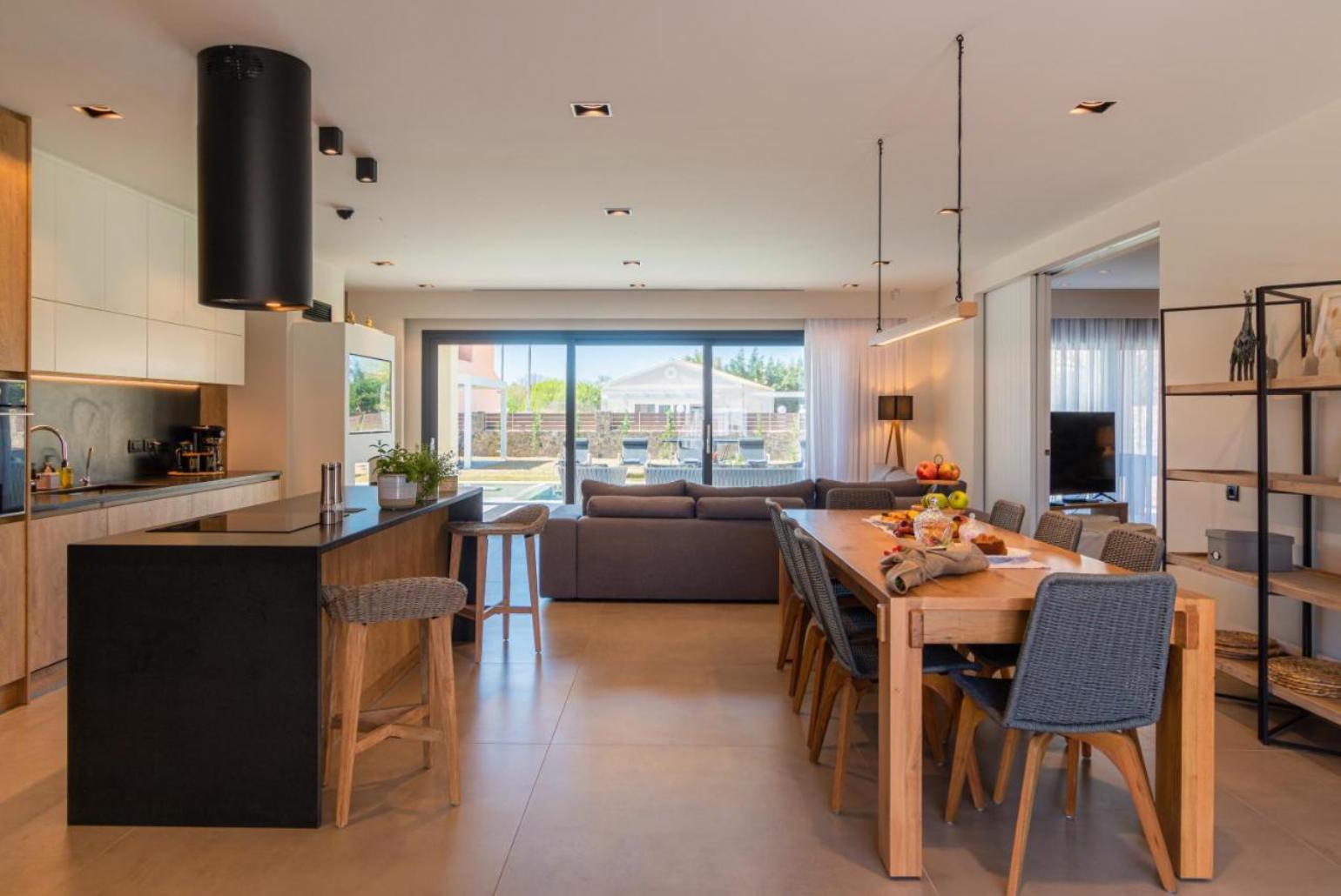 Open plan living room, dining table and equipped kitchen