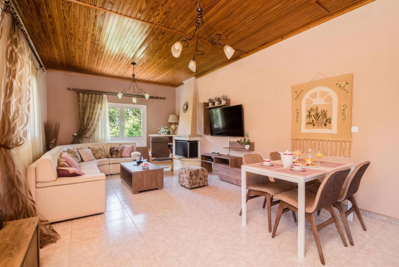 Open plan living room with A/C, TV, ornamental fireplace and dining table