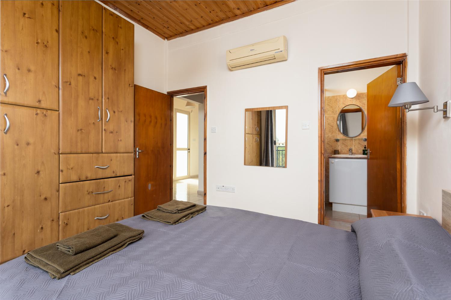 Double bedroom with en suite bathroom, A/C, and balcony access