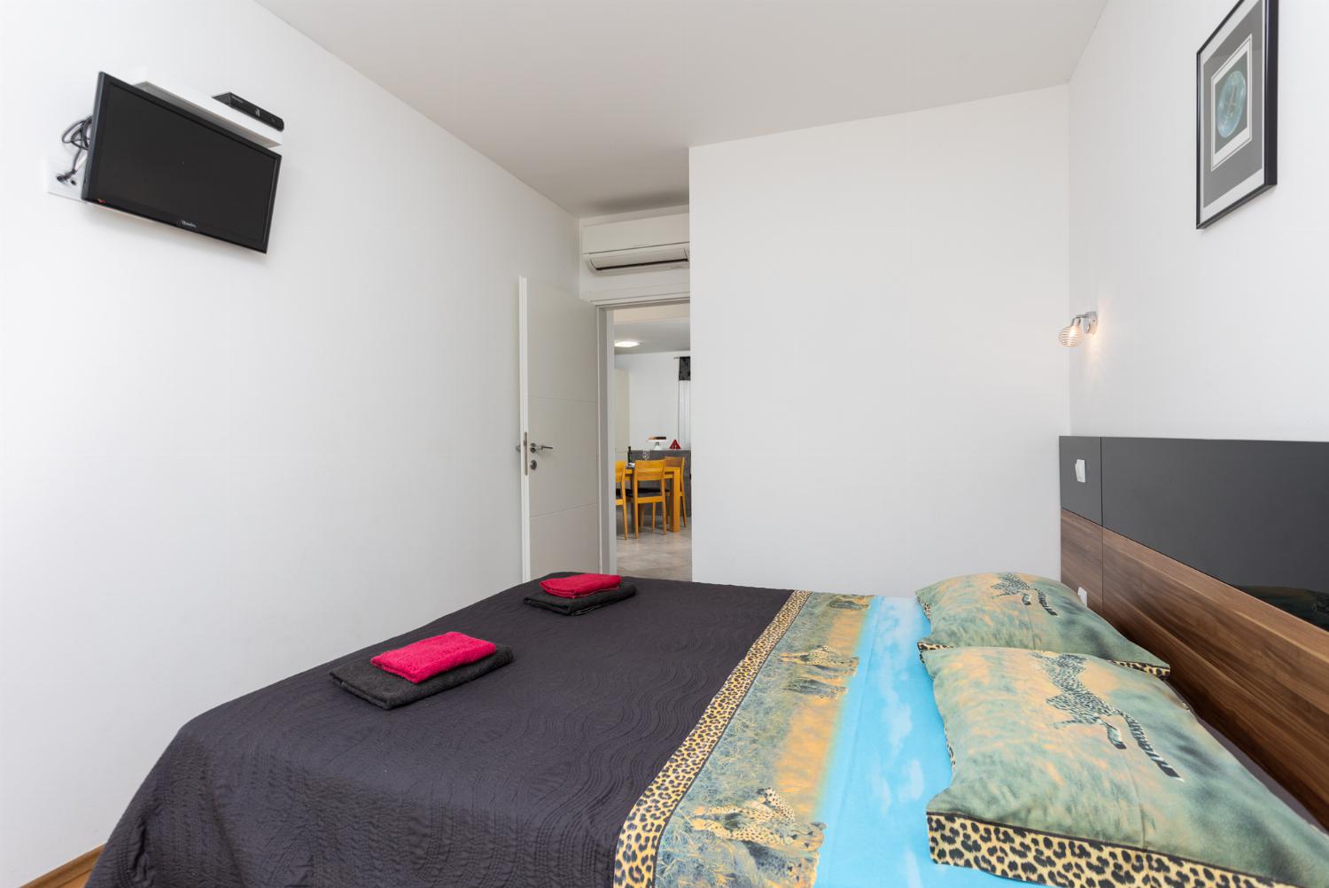 Double bedroom with en suite bathroom, A/C, and TV