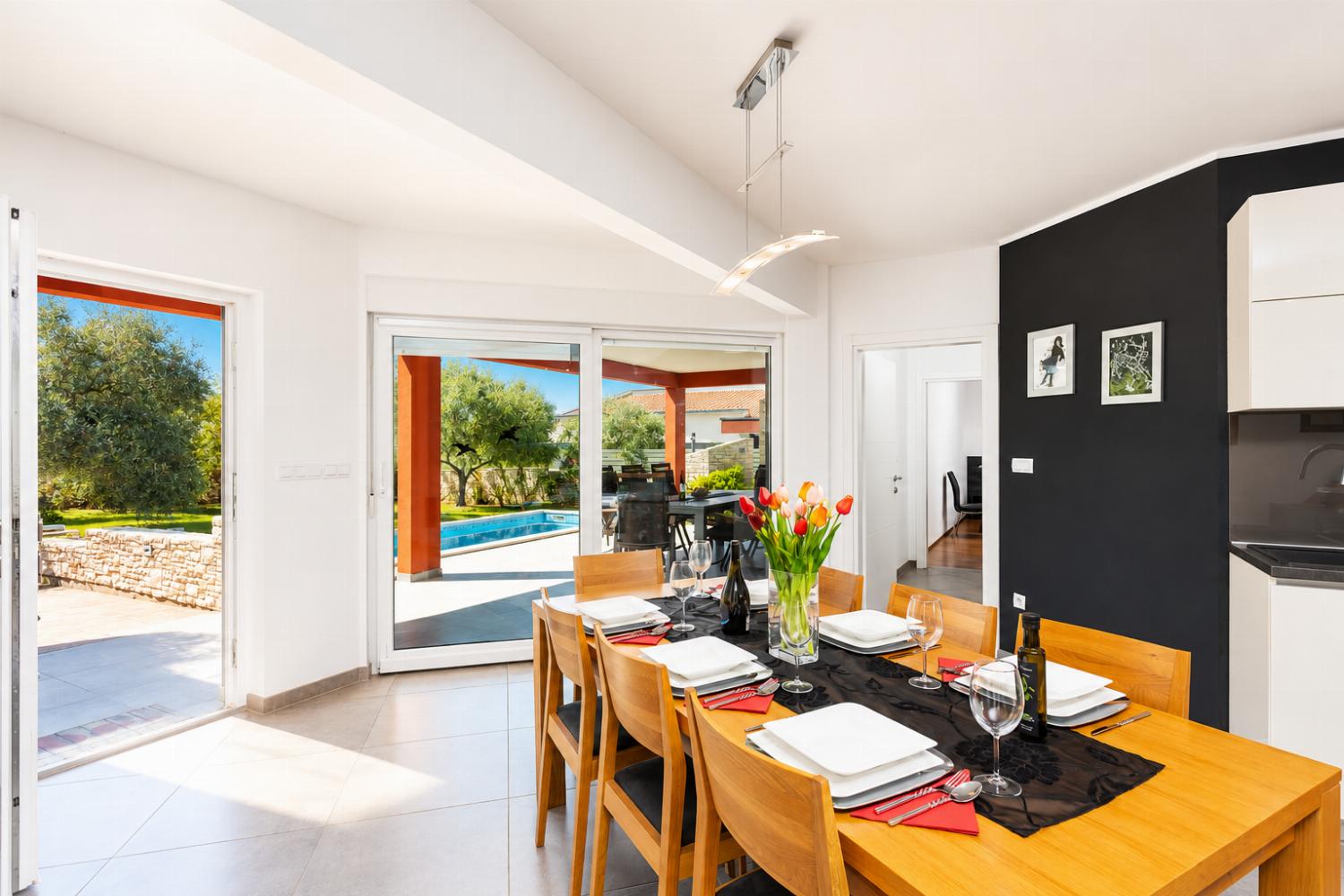 Open-plan living room with sofa, dining area, kitchen, A/C, WiFi internet, and satellite TV