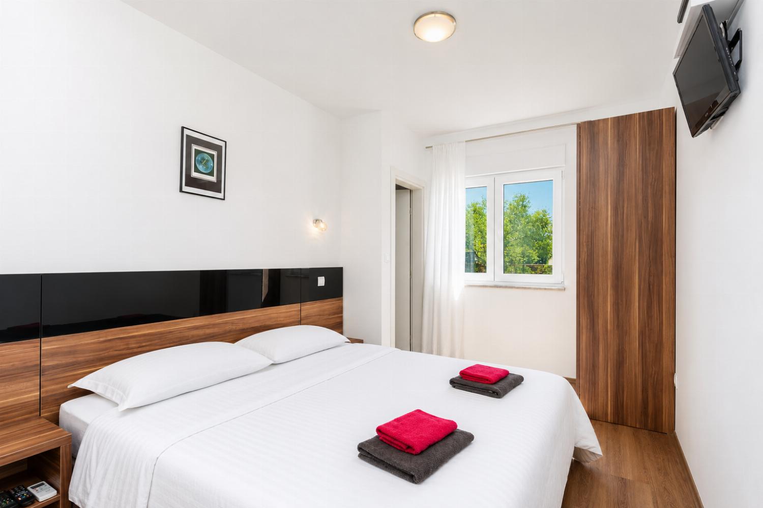 Double bedroom with en suite bathroom, A/C, and TV