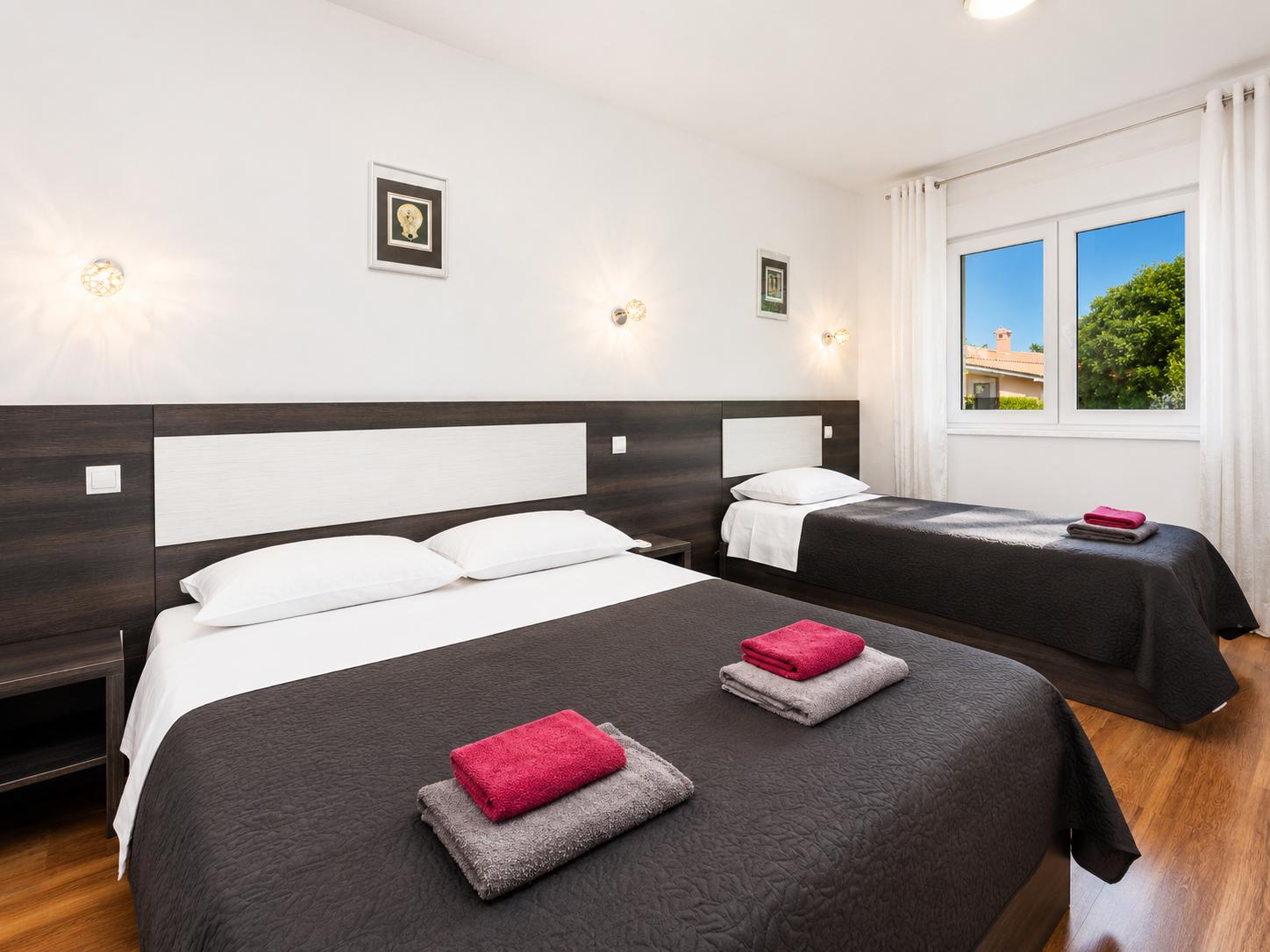 Bedroom (double bed and single bed) with en suite bathroom, A/C, and TV