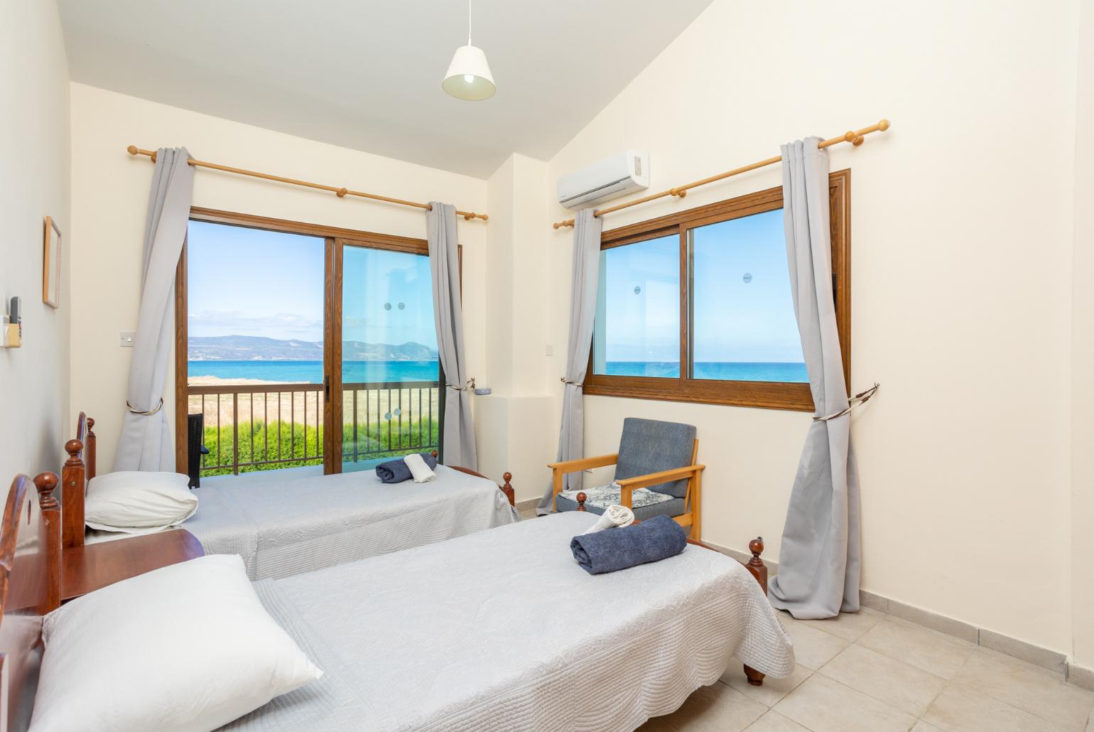 Twin bedroom with A/C, sea views, and balcony access