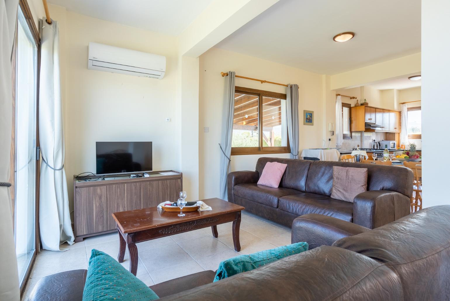 Open-plan living room with sofas, dining area, kitchen, A/C, WiFi internet, satellite TV, and sea views