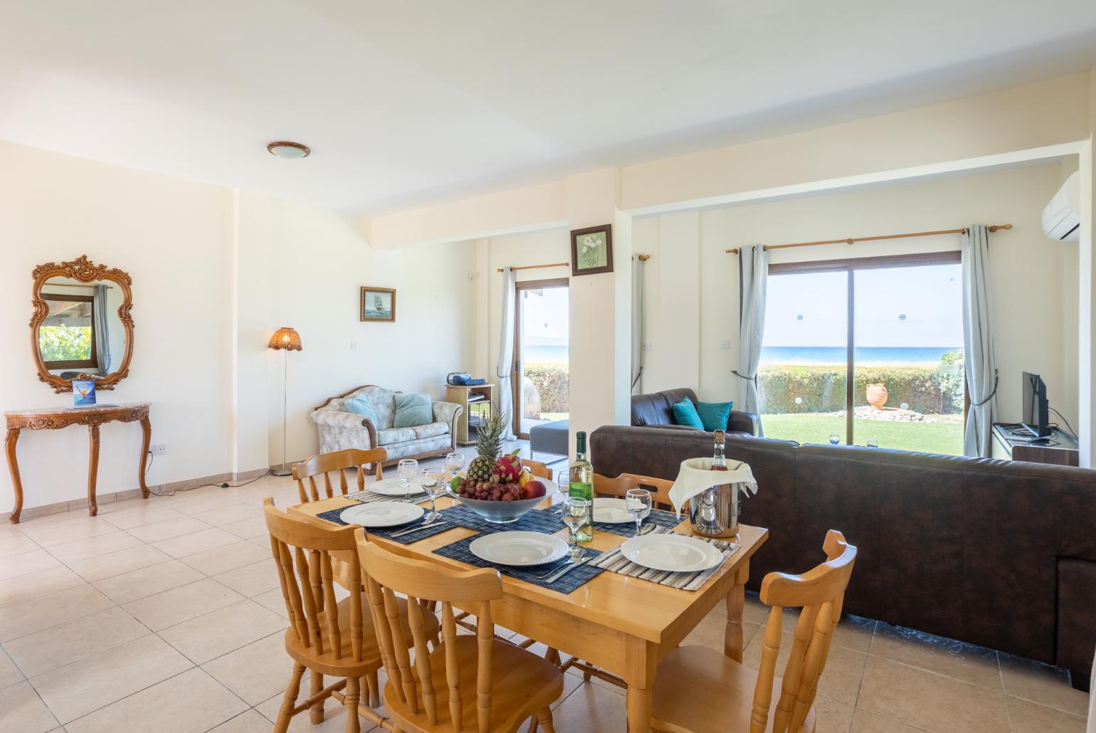 Open-plan living room with sofas, dining area, kitchen, A/C, WiFi internet, satellite TV, and sea views