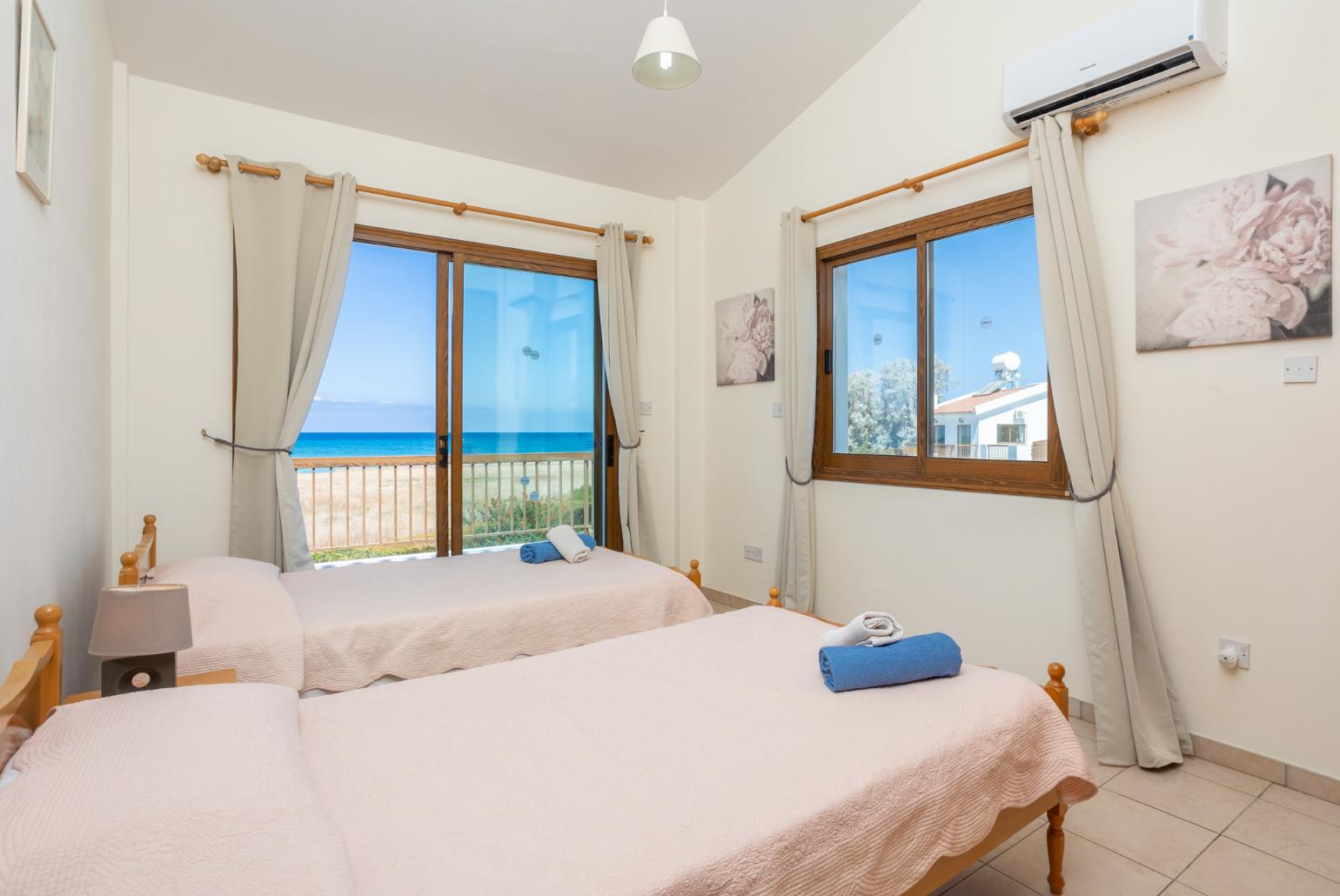 Twin bedroom with A/C, sea views, and balcony access