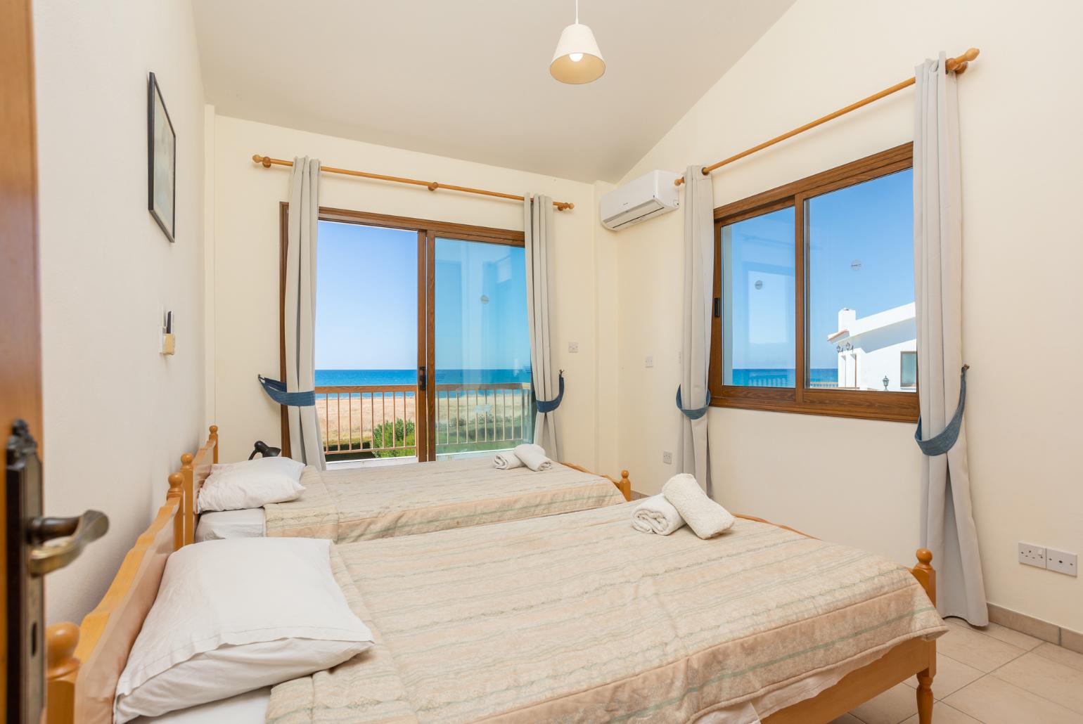 Twin bedroom with A/C, sea views, and balcony access