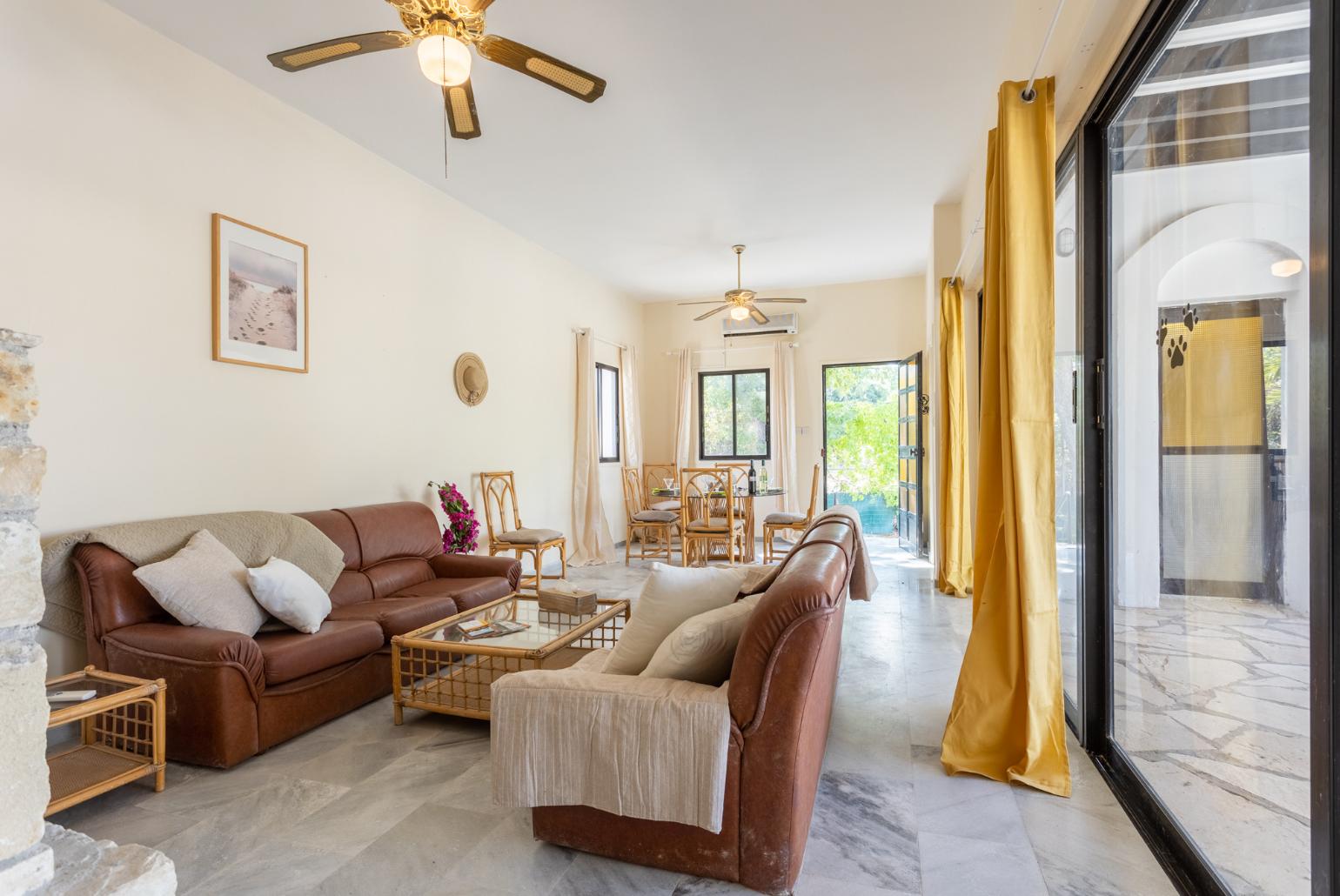 Living room with sofas, dining area, ornamental fireplace, A/C, WiFi internet, and satellite TV