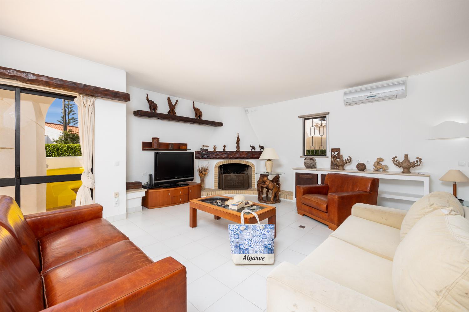 Living room with sofas, dining area, ornamental fireplace, A/C, WiFi internet, and satellite TV