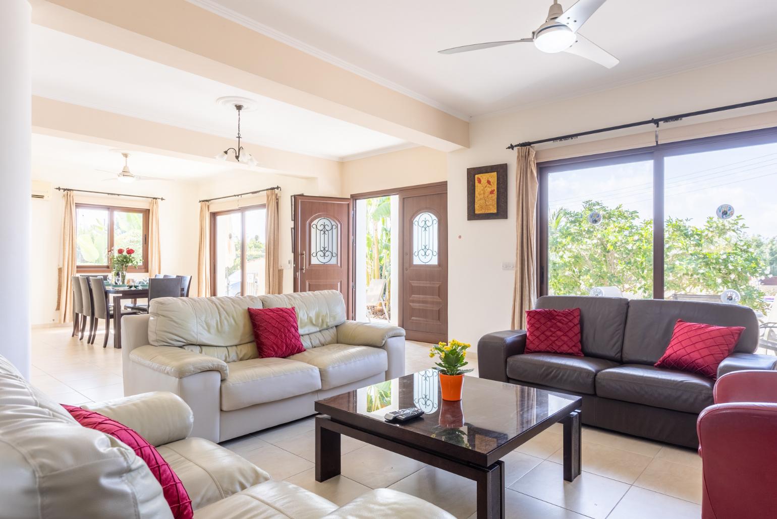 Open-plan living room with sofas, dining area, kitchen, ornamental fireplace, A/C, WiFi internet, and satellite TV