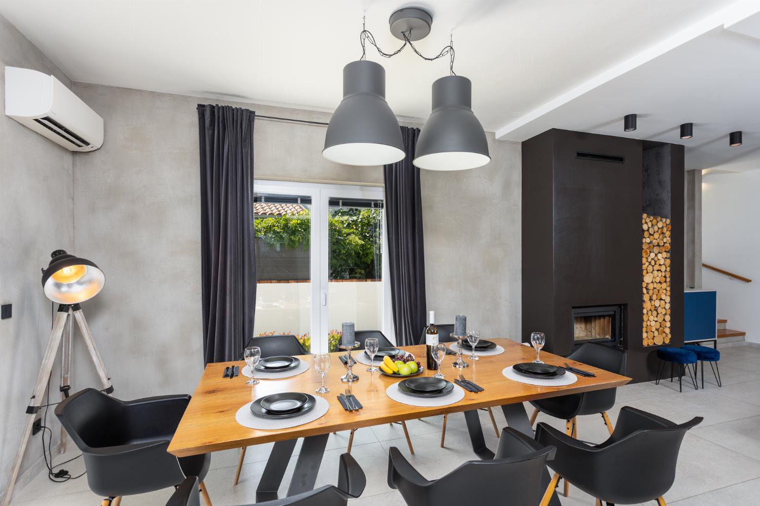 Open-plan living room with sofas, dining area, kitchen, pool table, ornamental fireplace, A/C, WiFi internet, and satellite TVs