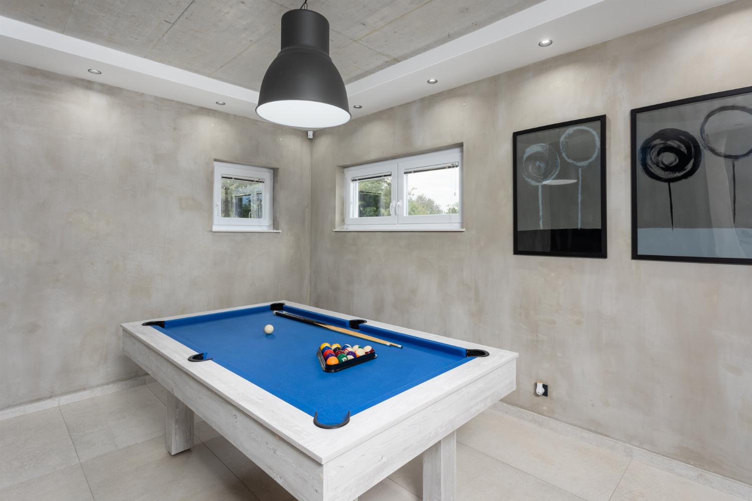 Open-plan living room with sofas, dining area, kitchen, pool table, ornamental fireplace, A/C, WiFi internet, and satellite TVs