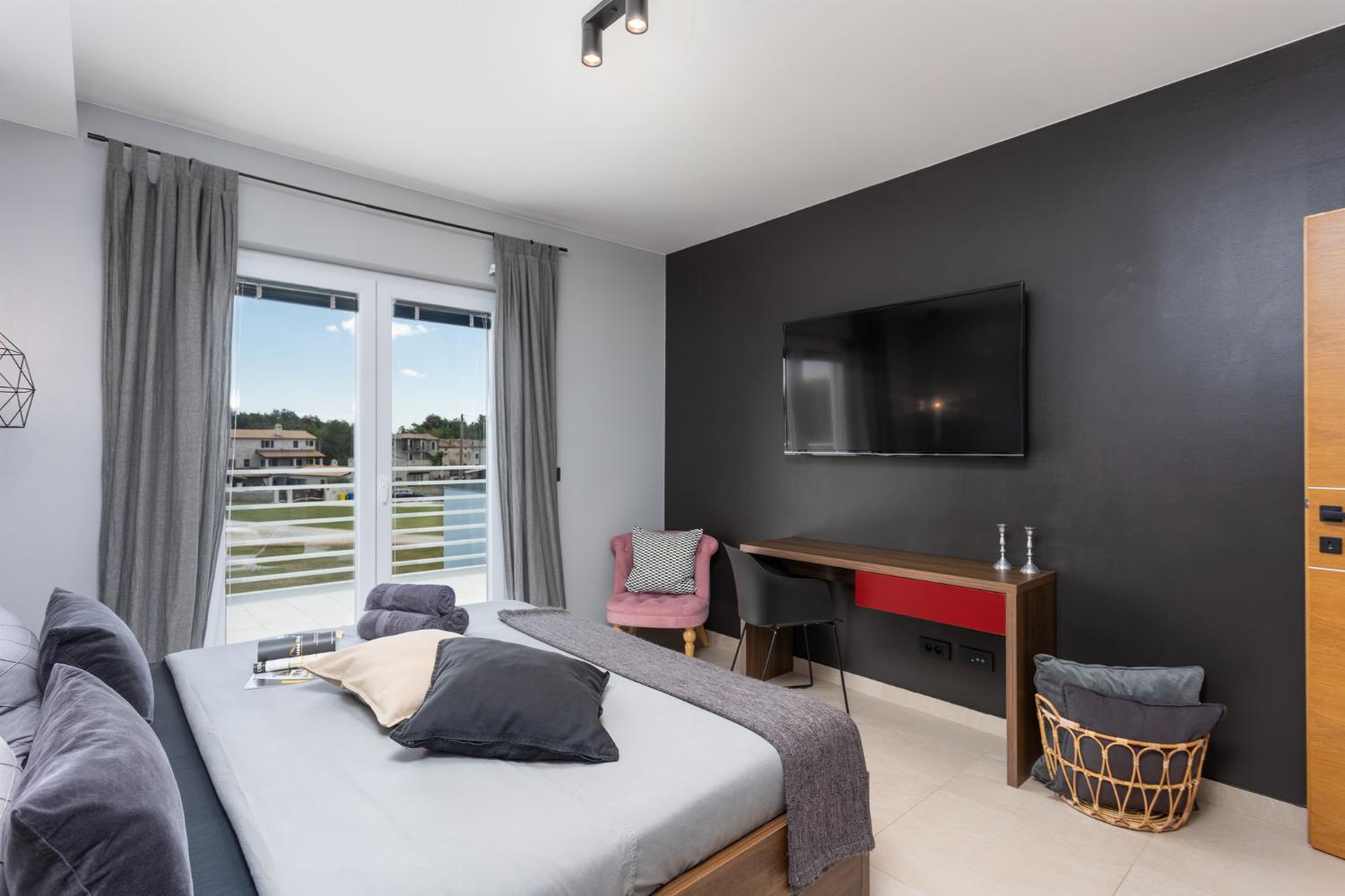Double bedroom with en suite bathroom, A/C, TV, and balcony access