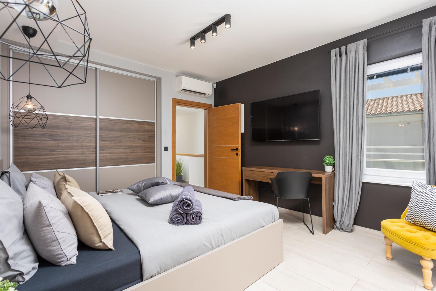 Double bedroom with en suite bathroom, A/C, TV, and balcony access