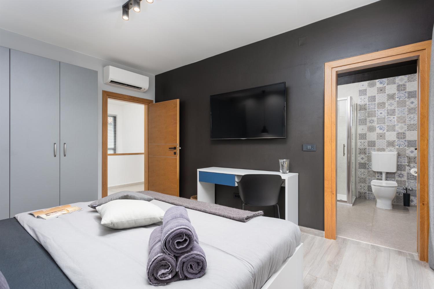 Double bedroom with en suite bathroom, A/C, and TV