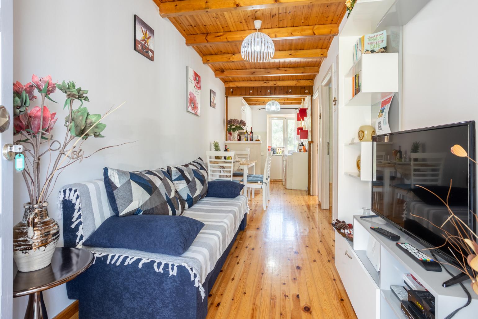 Open-plan living room with sofa, dining area, kitchen, WiFi internet, satellite TV, and terrace access