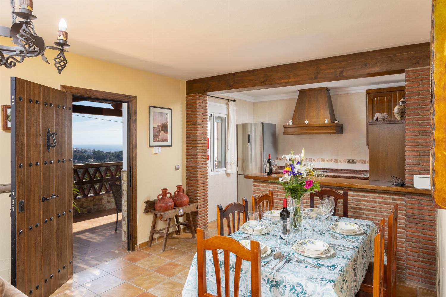 Open-plan living room with sofas, dining area, kitchen, ornamental fireplace, WiFi internet, satellite TV, and sea views