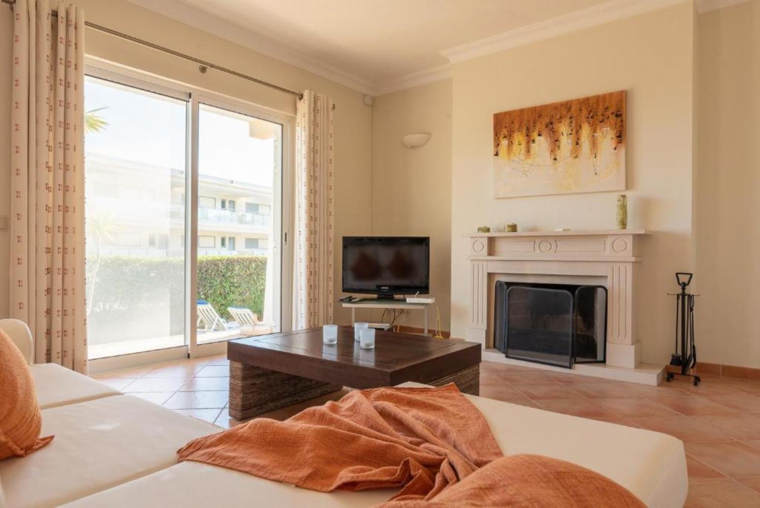 Living room with comfortable sofa, TV and ornamental fire place