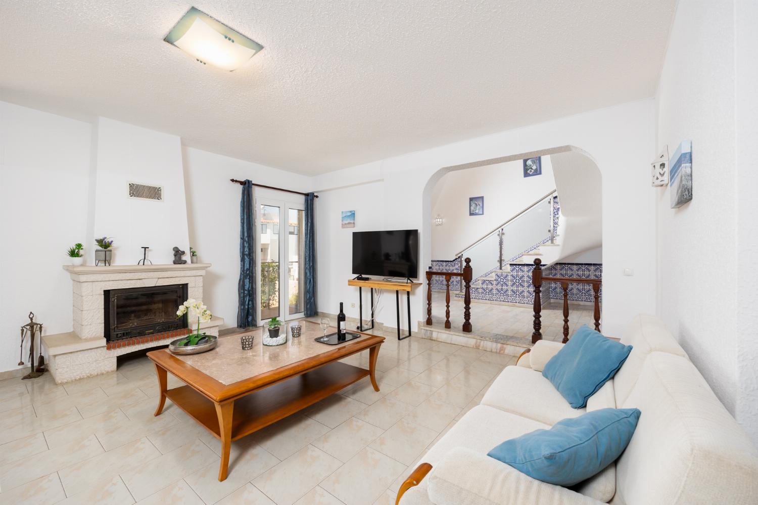 Living room with sofas, dining area, ornamental fireplace, A/C, WiFi internet, and satellite TV