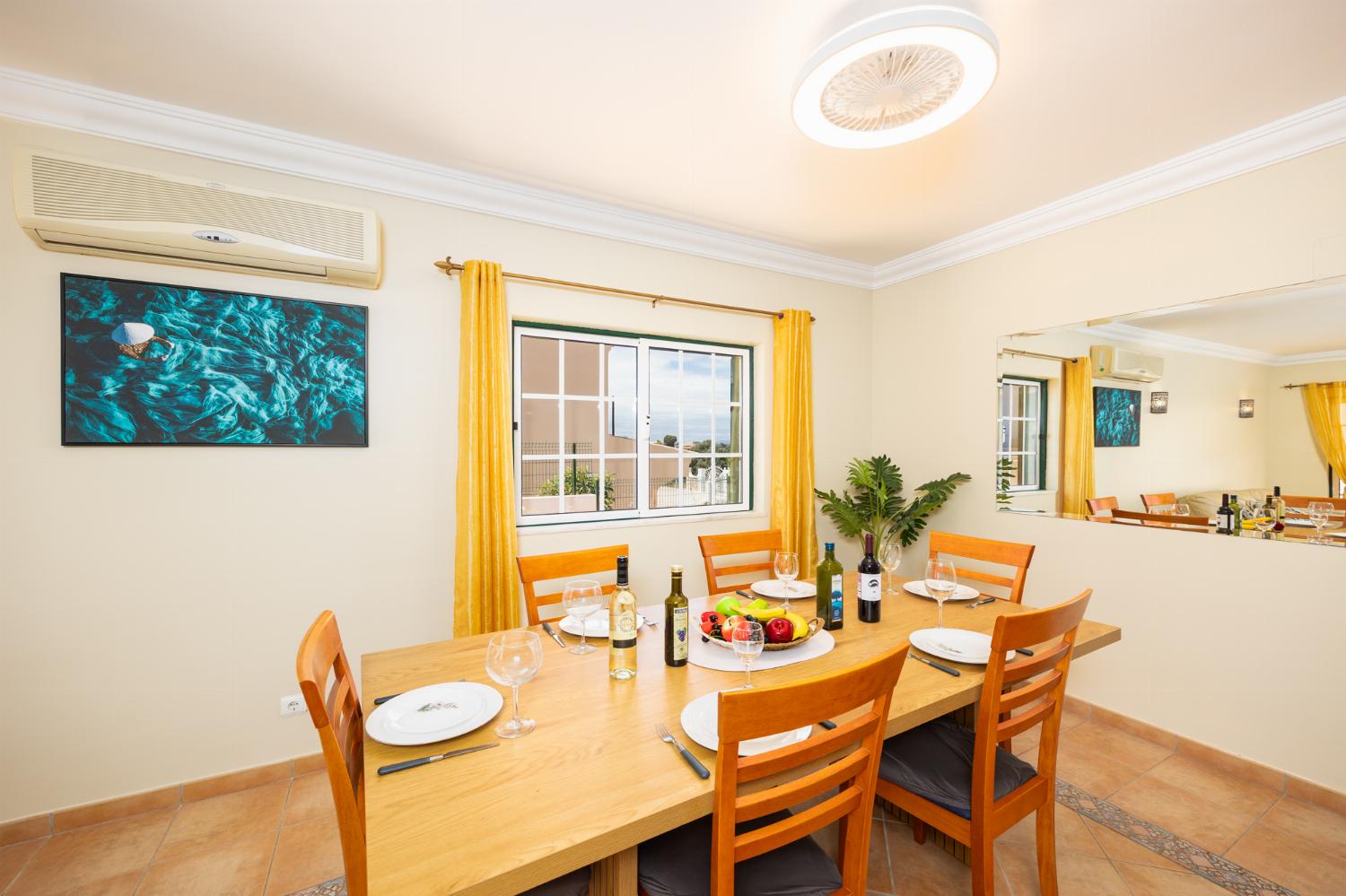 Open-plan living room with sofas, dining area, ornamental fireplace, A/C, WiFi internet, and satellite TV