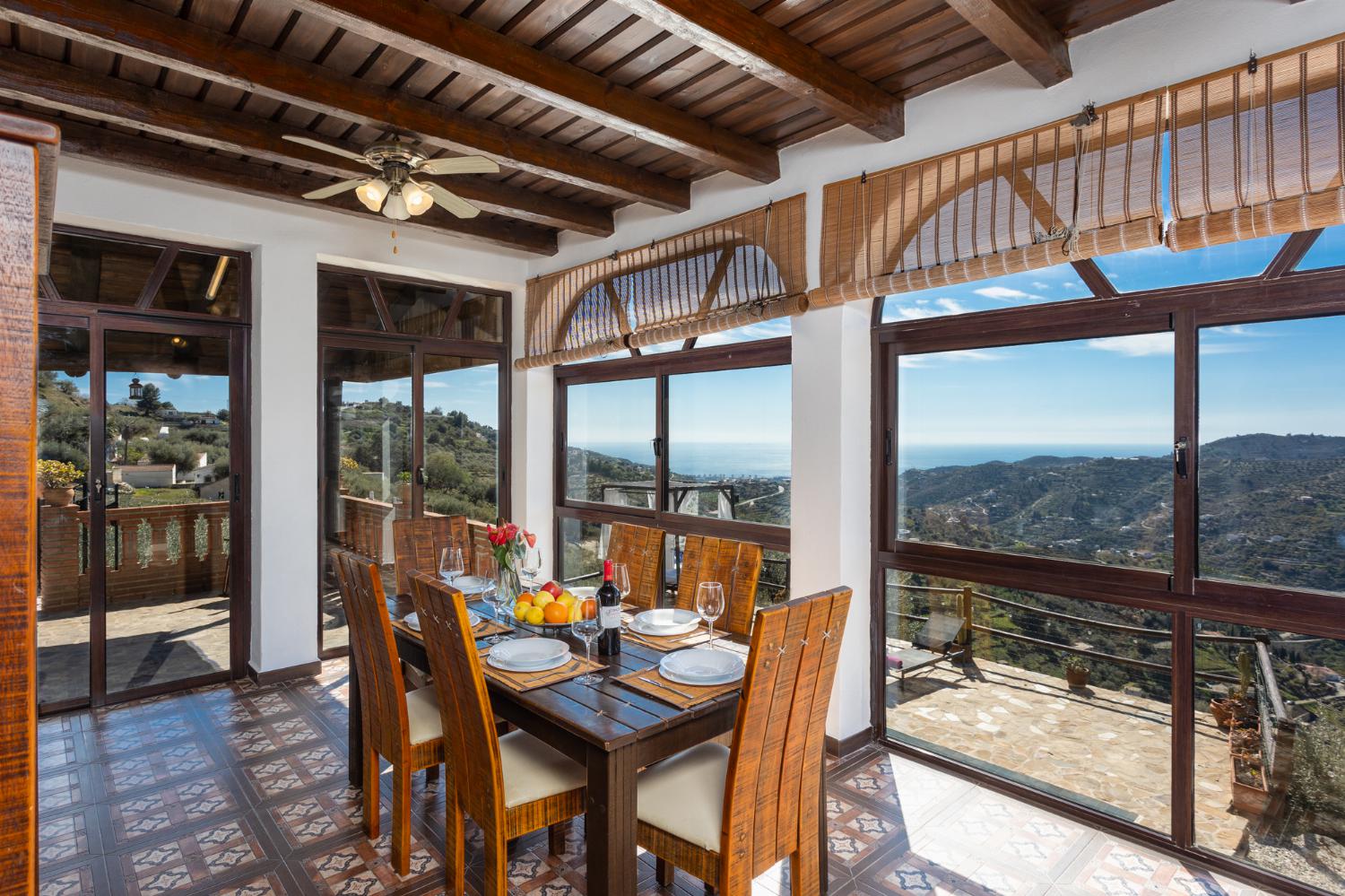 Open-plan living room with sofas, dining area, kitchen, ornamental fireplace, A/C, WiFi internet, satellite TV, and sea views