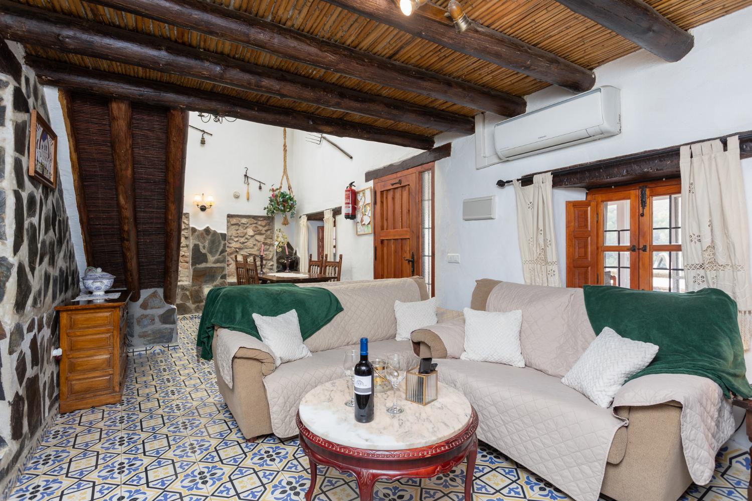 Living room with sofas, dining area, mezzanine, ornamental fireplace, A/C, WiFi internet, and satellite TV