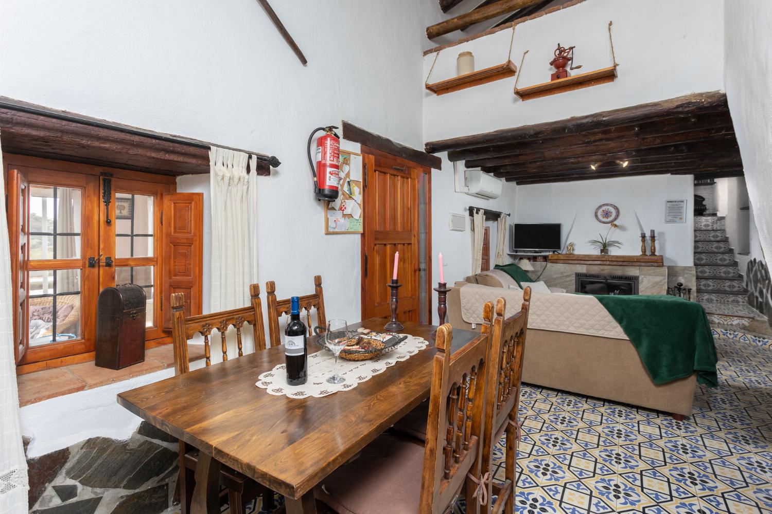 Living room with sofas, dining area, mezzanine, ornamental fireplace, A/C, WiFi internet, and satellite TV