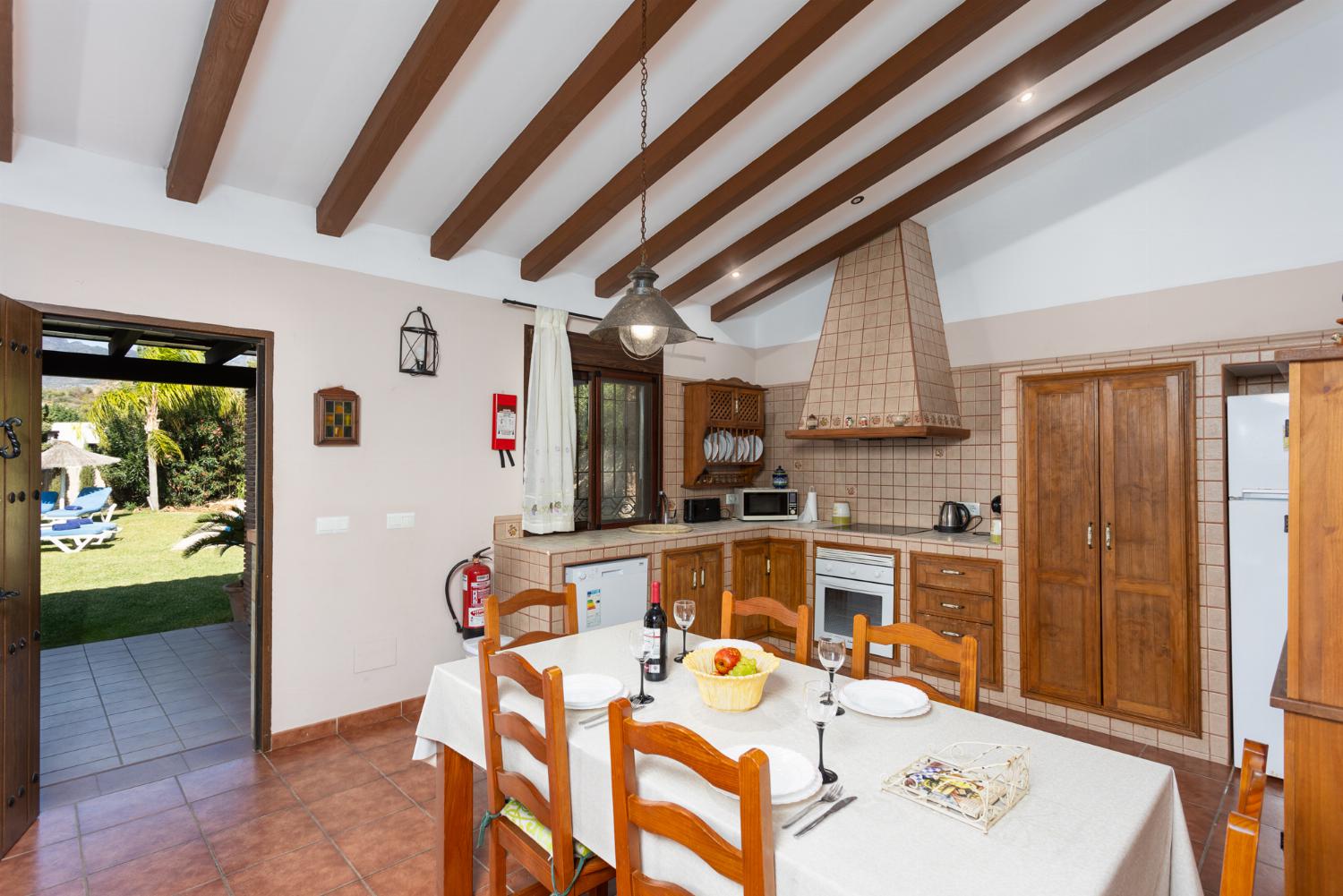 Open-plan living room with sofa, dining area, kitchen, ornamental fireplace, WiFi internet, and satellite TV