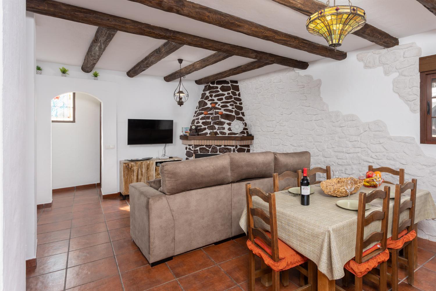 Living room with sofa, dining area, ornamental fireplace, WiFi internet, and satellite TV