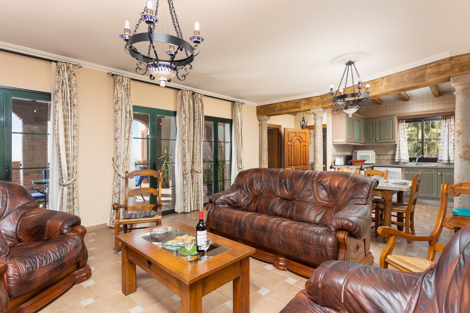 Open-plan living room with sofas, dining area, kitchen, ornamental fireplace, A/C, WiFi internet, satellite TV, and sea views