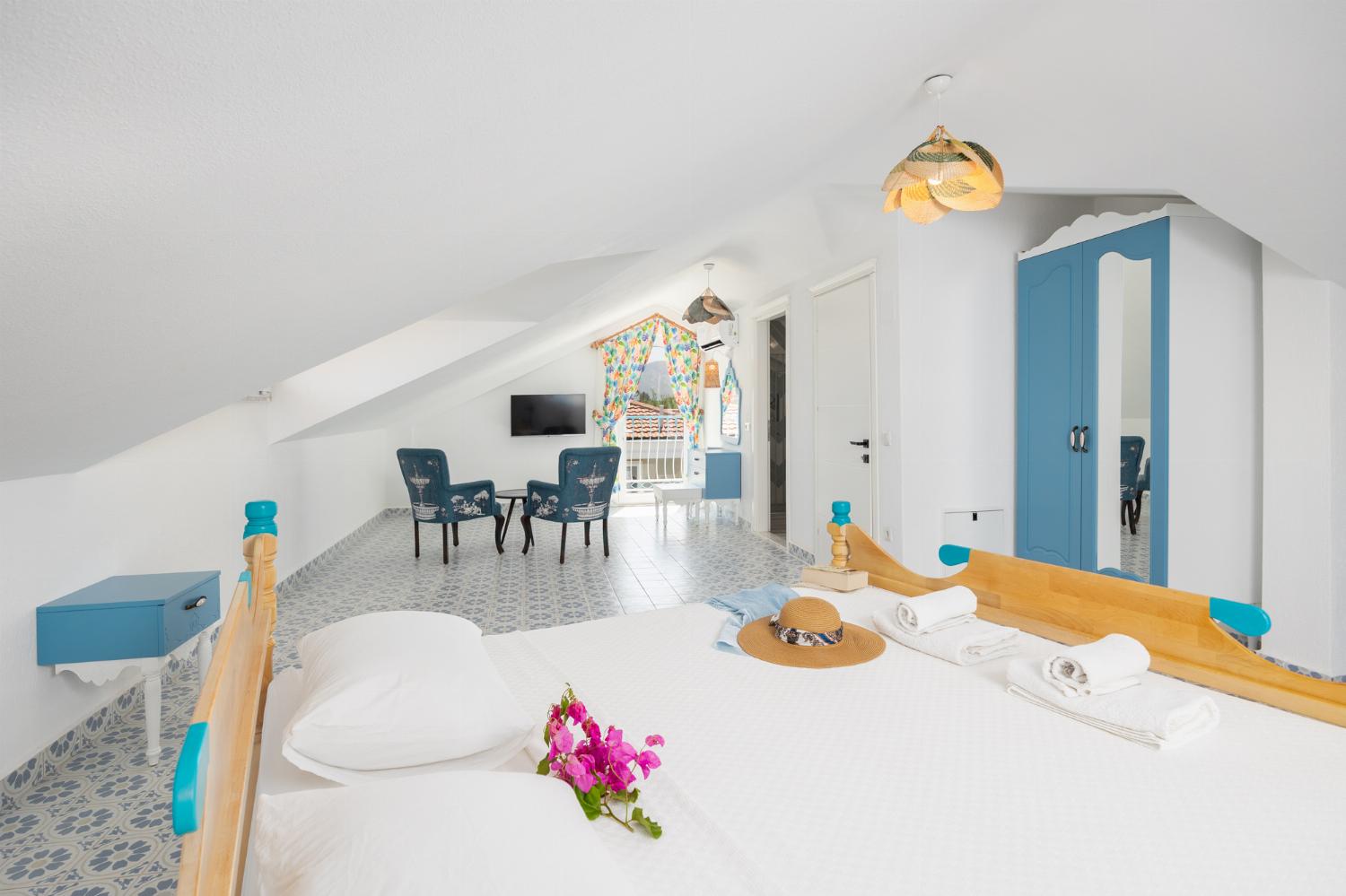 Double bedroom with en suite bathroom, seating, TV, and A/C