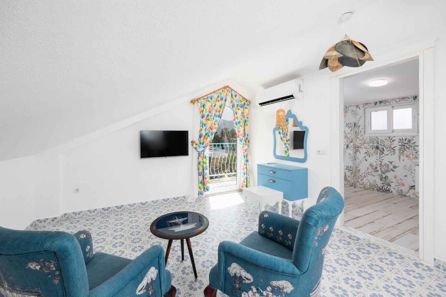 Double bedroom with en suite bathroom, seating, TV, and A/C