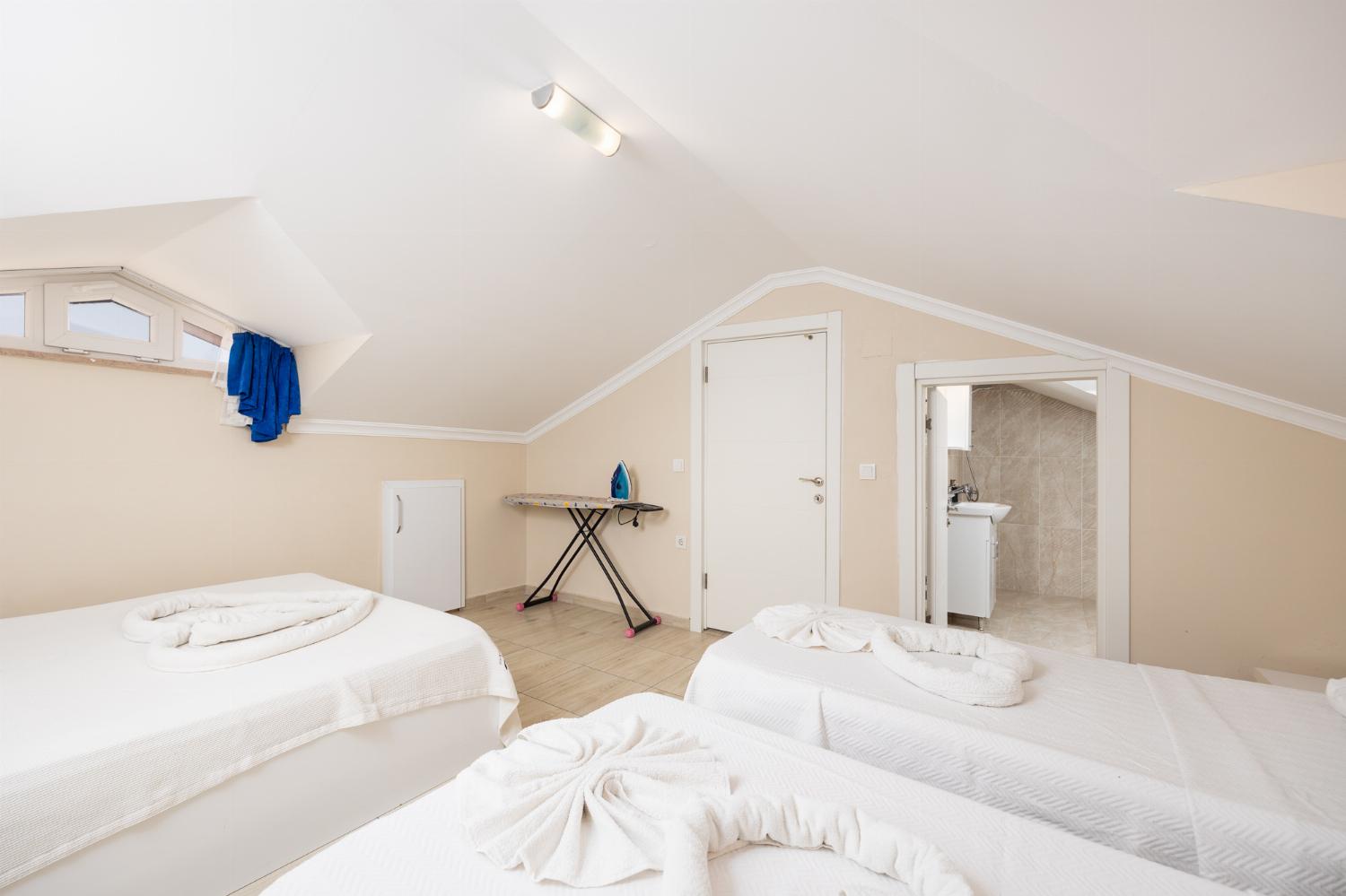 Bedroom with double bed and two single beds, en suite bathroom, and A/C