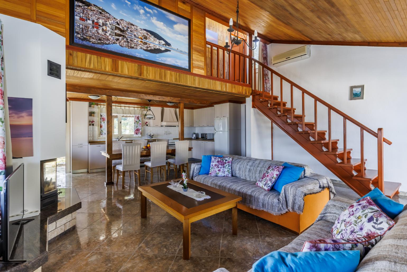 Open plan living room with A/C, ornamental fireplace and TV