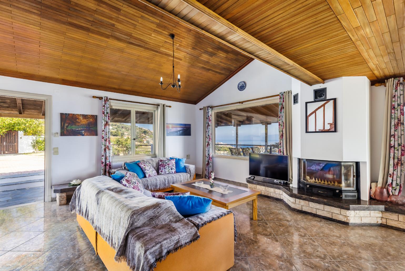 Open plan living room with A/C, ornamental fireplace and TV