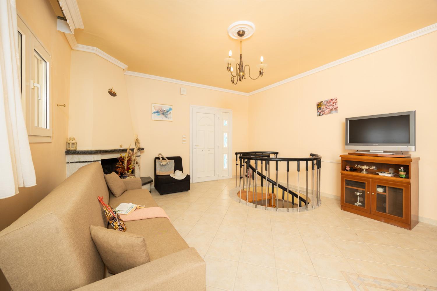 First floor: open-plan living room with sofa, dining area, kitchen, ornamental fireplace, A/C, WiFi internet, satellite TV, and sea views