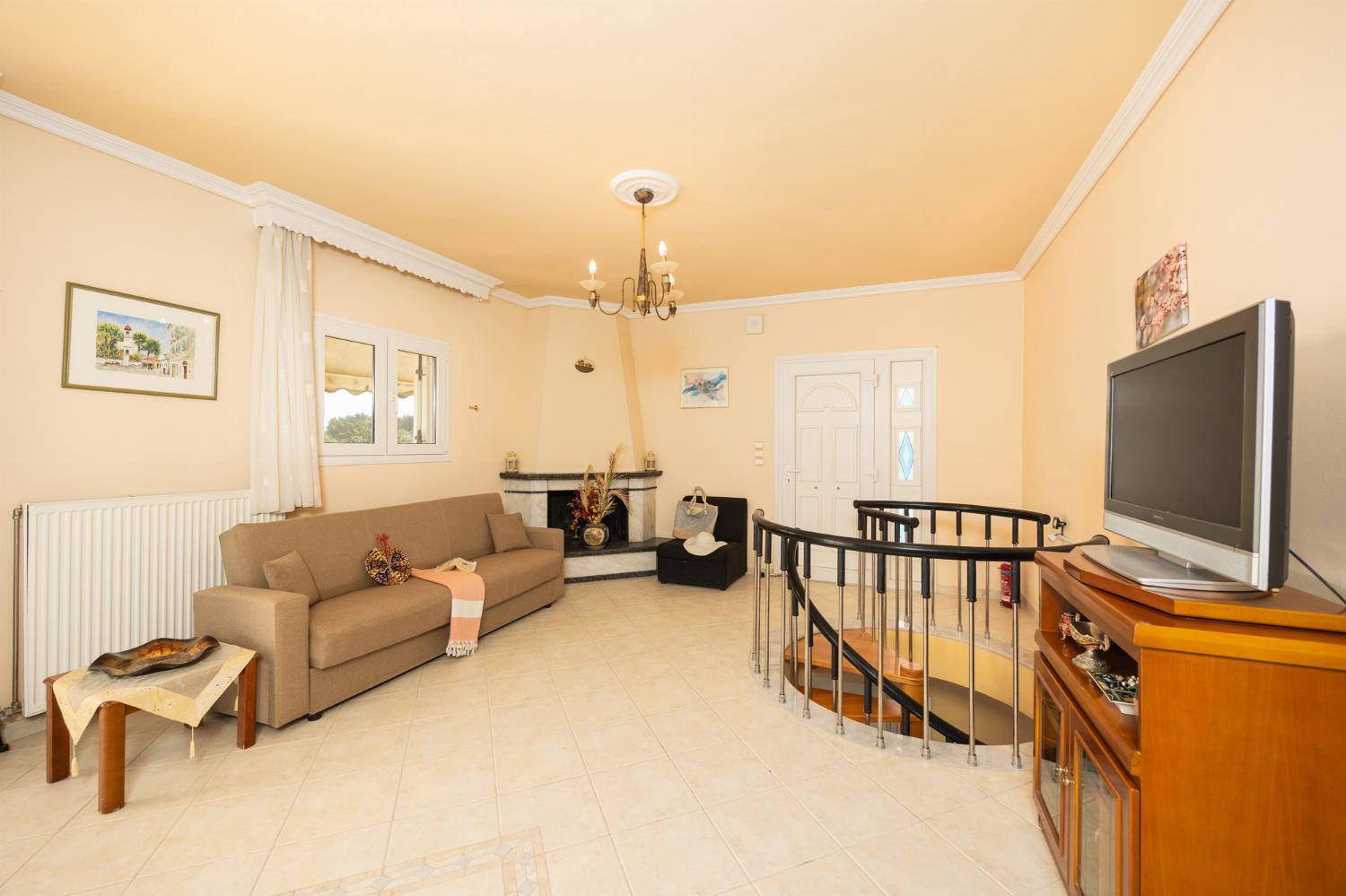 First floor: open-plan living room with sofa, dining area, kitchen, ornamental fireplace, A/C, WiFi internet, satellite TV, and sea views