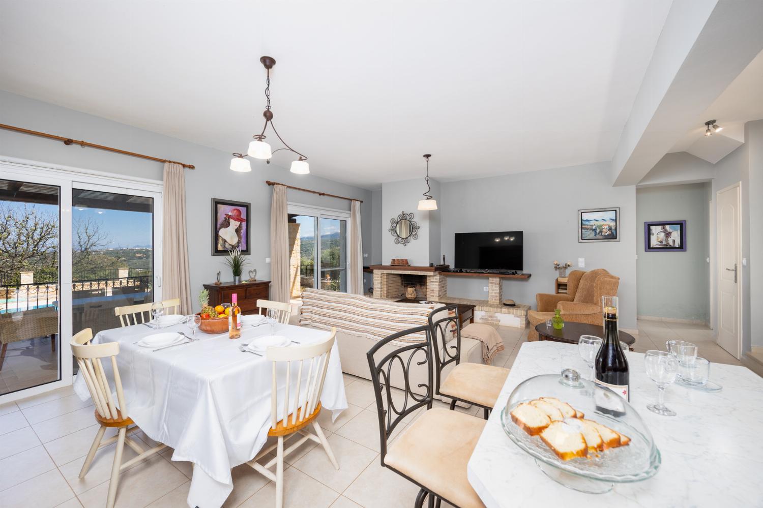 Open-plan living room with sofa, dining area, kitchen, ornamental fireplace, A/C, WiFi internet, and satellite TV