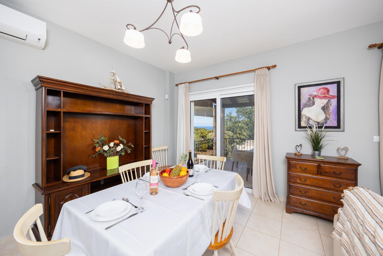 Open-plan living room with sofa, dining area, kitchen, ornamental fireplace, A/C, WiFi internet, and satellite TV