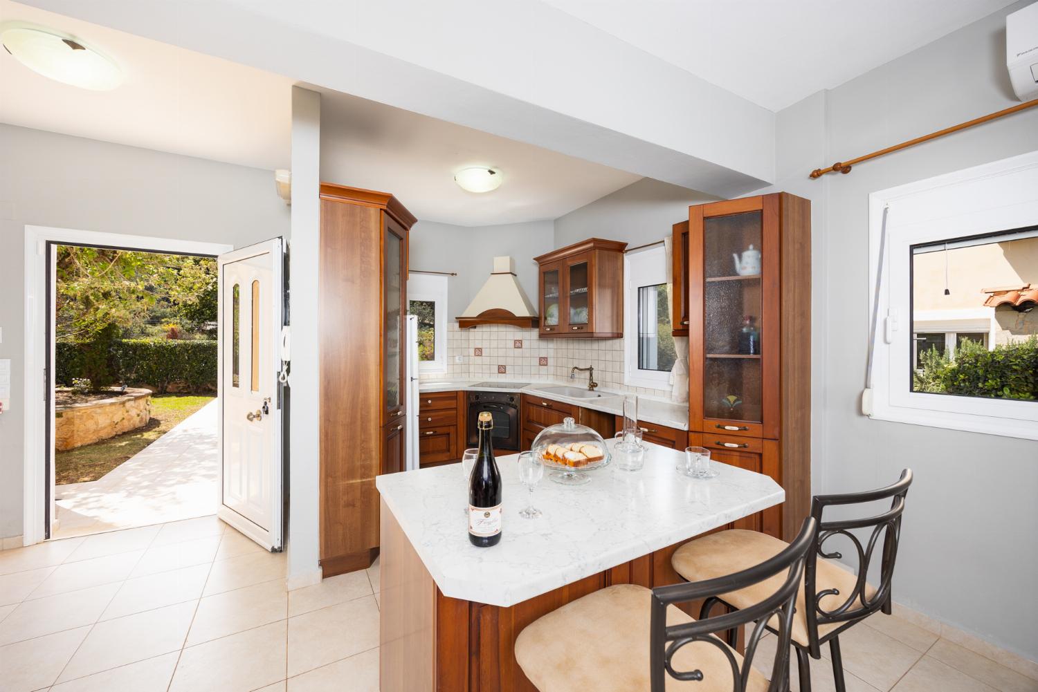 Open-plan living room with sofa, dining area, kitchen, ornamental fireplace, A/C, WiFi internet, and satellite TV