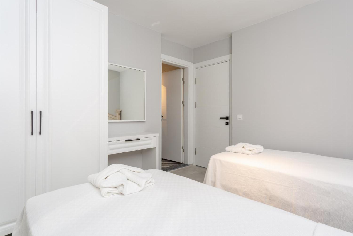 T win bedroom, with single beds, en suite bathroom, A/C and balcony access