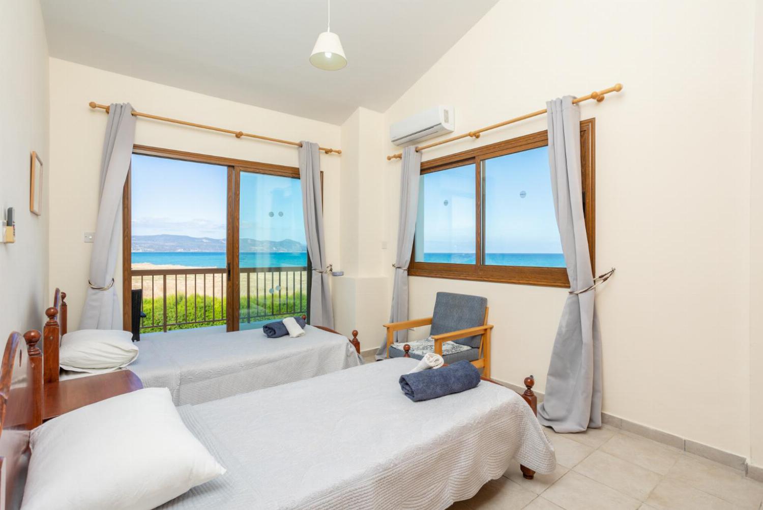 Twin bedroom with A/C, sea views, and balcony access