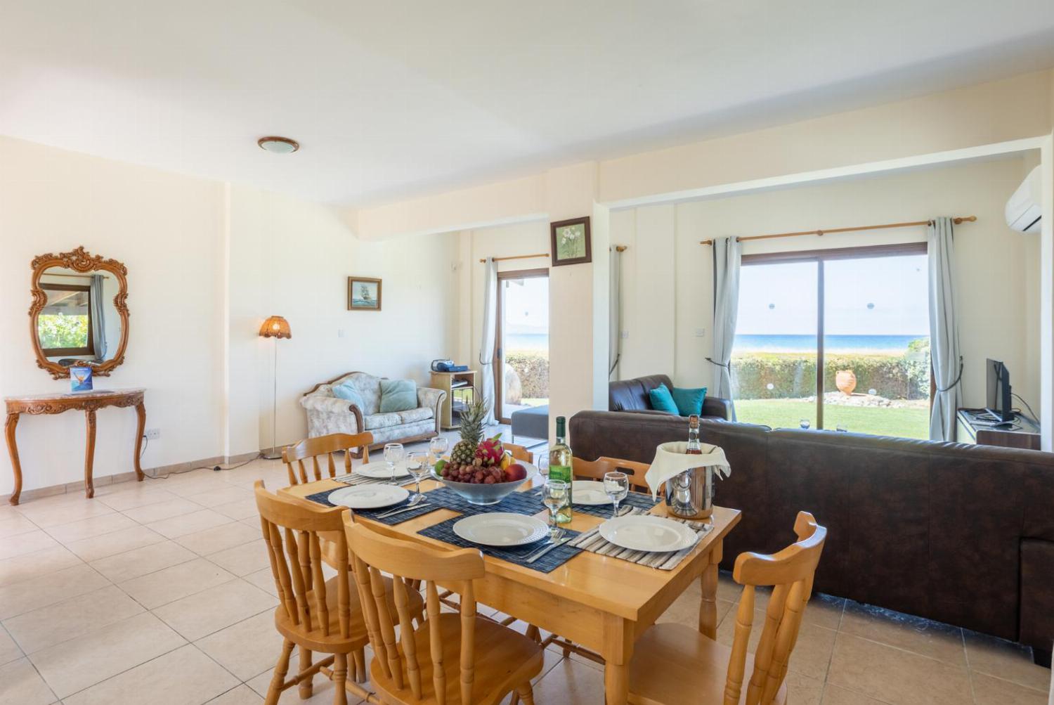 Open-plan living room with sofas, dining area, kitchen, ornamental fireplace, A/C, WiFi internet, satellite TV, and sea views