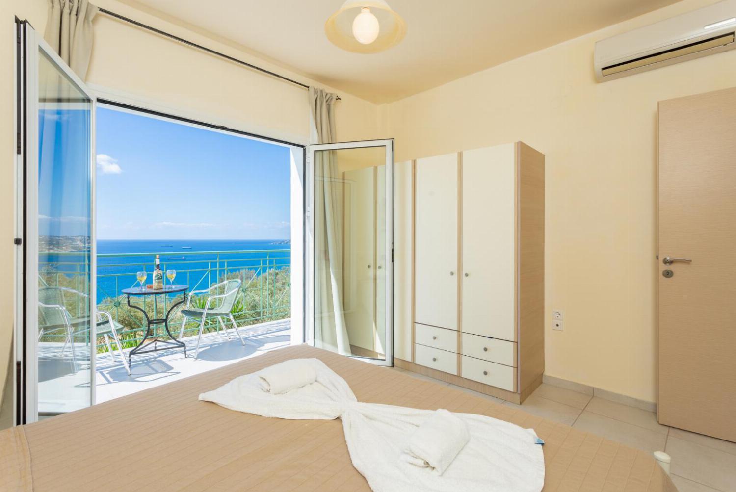 Double bedroom with en suite bathroom, A/C, and upper terrace access with panoramic sea views