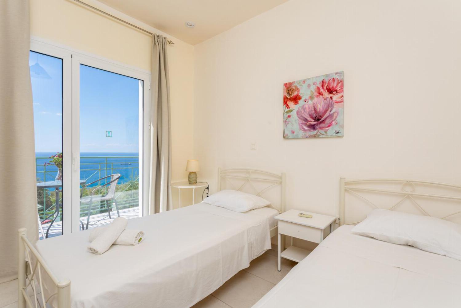 Twin bedroom with en suite bathroom, A/C, and upper terrace access with panoramic sea views